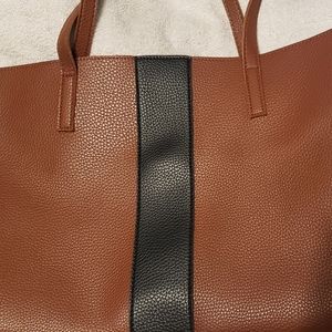Tan hobo leather bag with a black strip down the f